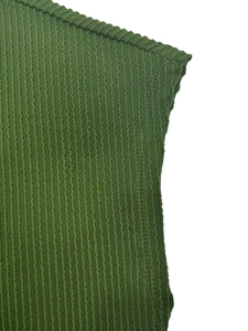 Close-up of green ribbed knit fabric showing high-quality shoulder and underarm stitching