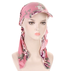 Detail of pink floral turban hat with brim showing fabric texture and vibrant pattern