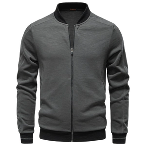 Detail of grey knitted jacket showing zipper texture and black ribbed collar cuffs