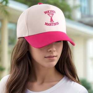 Detailed close-up of pink embroidered 'BIKINIS MARTINIS' logo on the vintage baseball cap