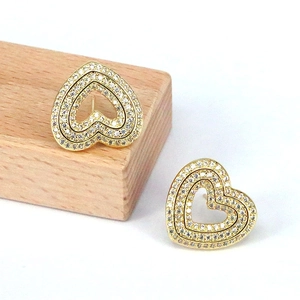 Detailed view of heart-shaped gold studs with micro-pave white zircon inlay on wood