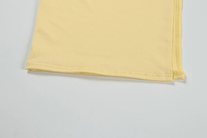 Detail of lemon yellow knit hem showing precise double-needle stitching and side edging