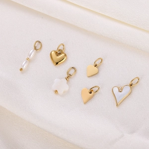 Set of 6 gold stainless steel pendants with pearl and shell hearts on beige fabric