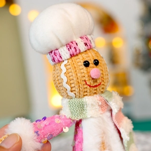 Detailed close-up of a Christmas plush chef doll with sequins and knitted textures
