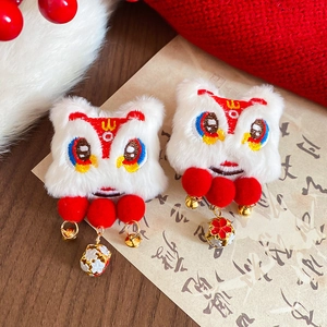 Detail showing plush lion dance hair clips with traditional embroidery and golden bells