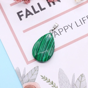 Green malachite teardrop pendant 10x28mm with silver metal clasp on floral background