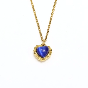 Macro view of blue heart gemstone pendant with vintage gold embossed border