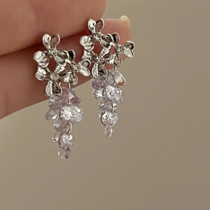 Detail of silver flower earrings with hanging light purple crystals in a tassel design