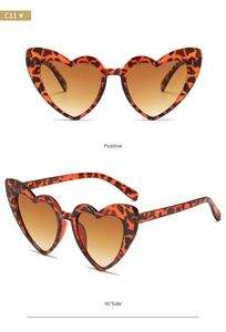 Detail view of heart-shaped sunglasses with leopard print frames and brown gradient lenses