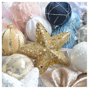 Close-up of assorted glitter Christmas tree baubles and stars in velvet and mesh texture