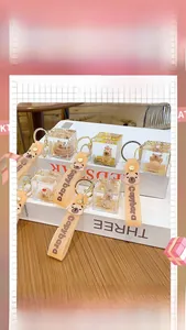 Detail of Capybara floating oil keychain with golden liquid sand and silicone wrist strap