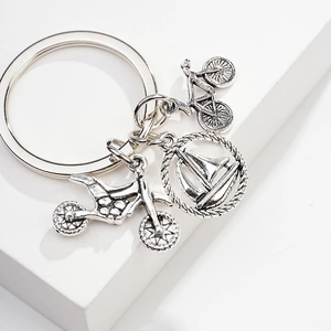 Silver metal keychain featuring detailed bicycle, motorcycle, and sailboat pendants