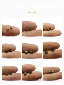 Detail of nine antique bronze alloy spacer beads with various vintage patterns for DIY jewelry