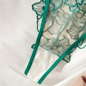 Detail of French floral embroidery on semi-transparent white mesh with green satin trim