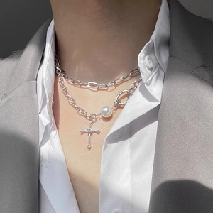 Double-layered silver necklace with rhinestone cross pendant and pearl accents on male model