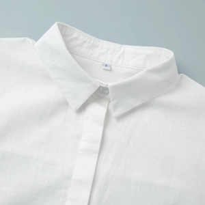 Close-up of white cotton linen shirt dress collar and fabric texture with hidden buttons