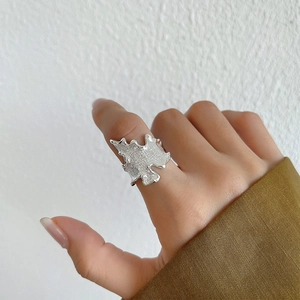 Macro view of 925 sterling silver ring with organic lava texture on index finger