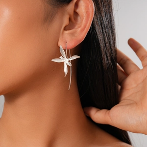 Detail of silver iris flower earring with long metal tassel on a model side profile