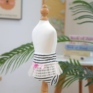 Close-up of dog sanitary pants with black-white stripes, pink bows and lace details