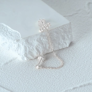 Macro detail of S925 sterling silver chain earrings with shimmering cubic zirconia stones