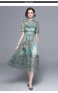 Detailed embroidery and beadwork on a green mesh long dress with floral patterns