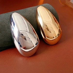 Minimalist irregular drop brooches in polished gold and silver on leather background