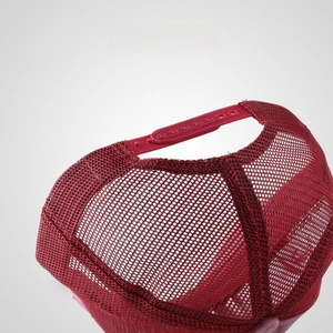 Detail of red trucker hat featuring breathable mesh and adjustable plastic snapback strap