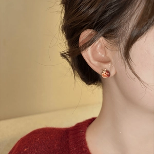 Elegant red pomegranate earrings with gold plating and zircons worn by a female model