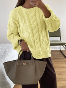 Detail of yellow chunky cable knit pattern on long sleeve crew neck sweater