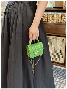 Close-up of green quilted jelly bag with gold twist lock and chain strap details