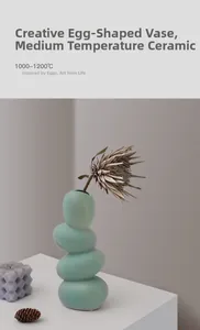 Détail du vase en céramique vert menthe en forme d'œuf organique sur un socle blanc