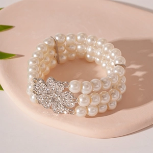 Macro shot of multi-layer pearl bracelet with rhinestone-encrusted flower buckle clasp
