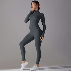 Detail of charcoal gray long sleeve sports jacket with thumb holes and matching yoga pants