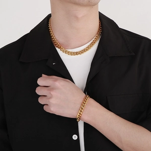 Ensemble collier et bracelet maille gourmette en acier titane doré sur mannequin