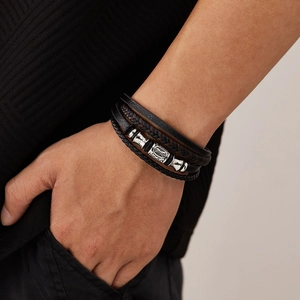 Close-up of multilayer braided black leather bracelet with silver metal beads on wrist