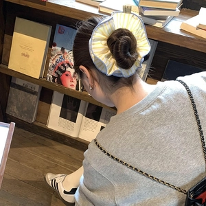 Oversized yellow striped scrunchie on high bun for French style hair decoration