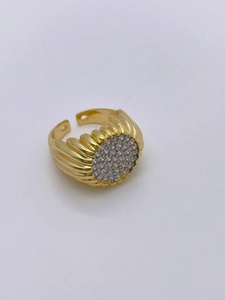 Detailed macro view of wide gold plated irregular ring with zircon paved round top