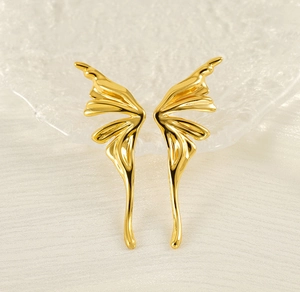 Macro shot of elegant gold butterfly wing earrings with detailed metallic textures
