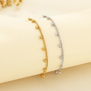Detail of gold and silver beaded anklets elegantly draped on a cylindrical display stand