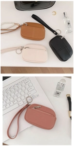 Detail of lychee textured leather coin purse with zipper closure and metal keychain ring