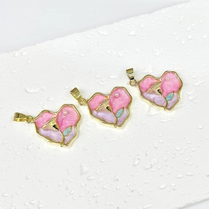 Vintage heart pendants with rose pattern and small pearl in gold frame on white surface