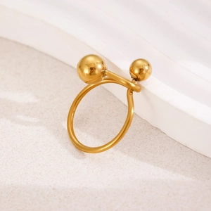 Macro view of golden stainless steel open ring featuring a double ball geometric design
