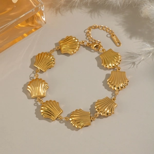 Detailed view of golden shell link bracelet with lobster clasp and adjustable chain extender