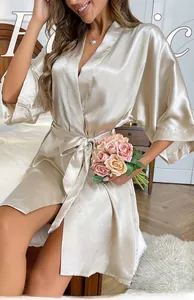 Detail of luxurious champagne gold satin robe with elegant V-neck and tied waist belt