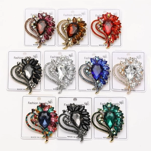 Flat lay macro of ten heart-shaped crystal brooches in various colors on white cards