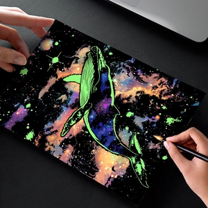 DIY glow-in-the-dark scratch art kit featuring a vibrant green whale in a colorful nebula