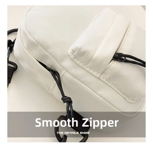Close-up of durable nylon small crossbody bag showing smooth zipper and black strap hooks