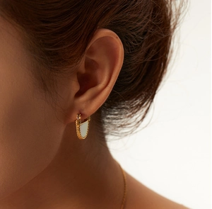 Elegant 18K gold-plated fan-shaped earrings with white mother-of-pearl worn by a model