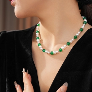 Dettaglio della collana vintage con agata verde e perle bianche su un modello