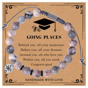 Detail of pink zebra stone graduation bracelet with compass charm on gift card